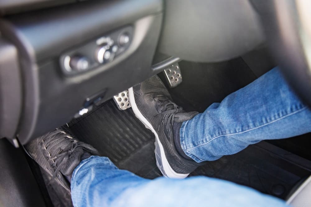 Driver pressing the brake pedal suddenly inside a car, illustrating brake checking behavior on Florida roads and its legal consequences.