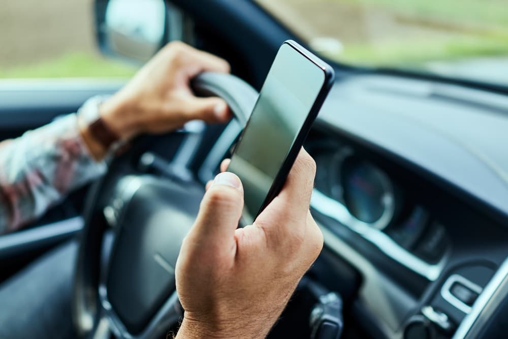 A man is using smart phone while driving