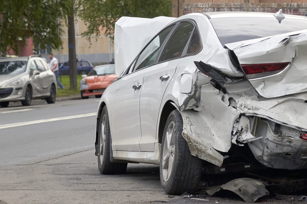 Da&ntilde;os en la parte trasera de un autom&oacute;vil blanco despu&eacute;s de un accidente automovil&iacute;stico