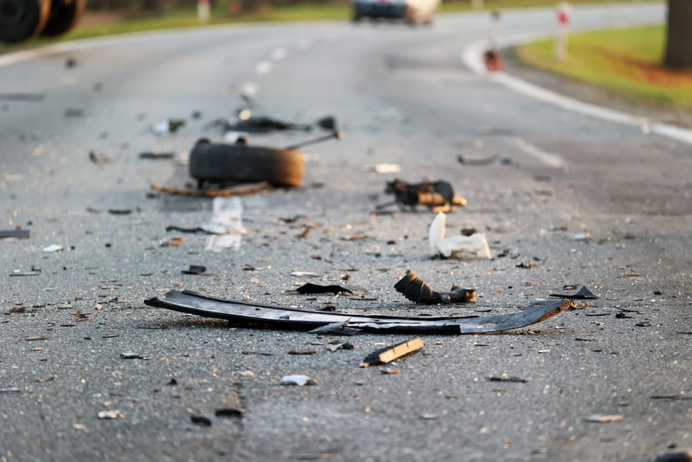 Escombros de veh&iacute;culos esparcidos en la carretera despu&eacute;s de un accidente automovil&iacute;stico