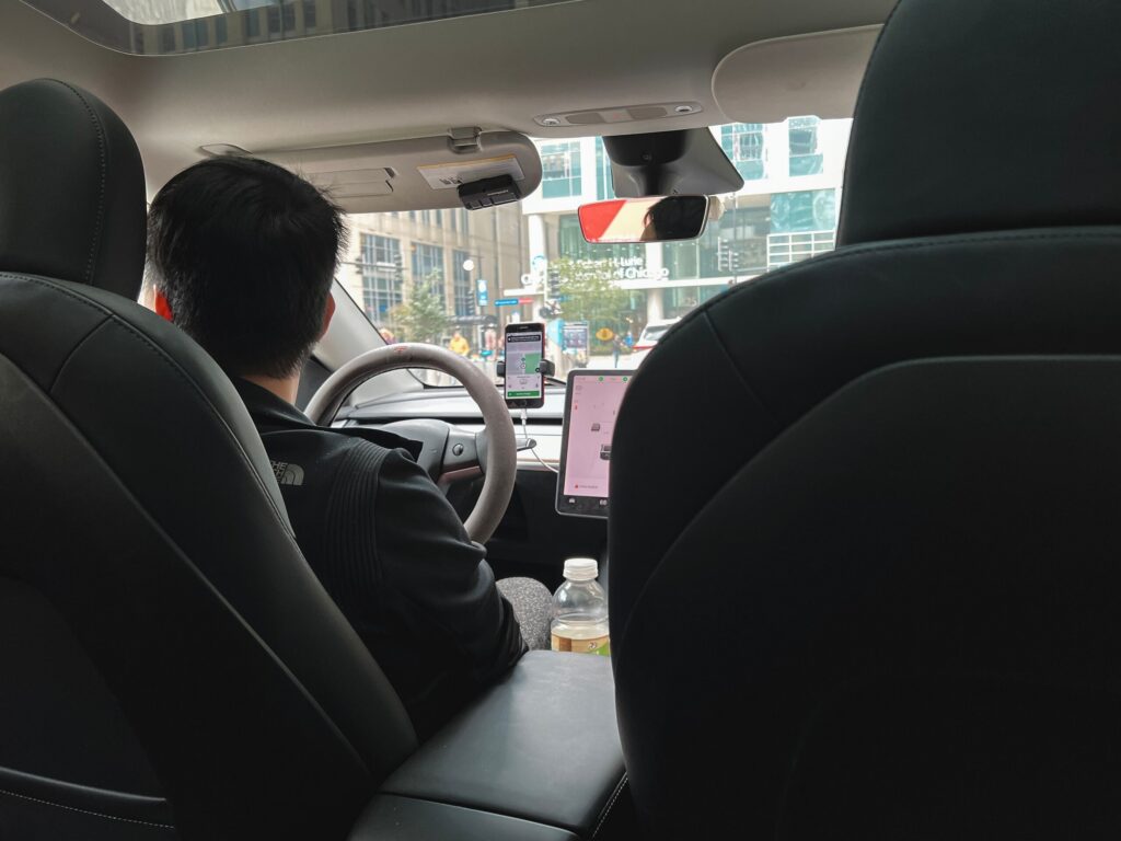 A driver operating a vehicle with a mounted navigation phone representing services from a Pembroke Pines Uber and Lyft Accident Lawyer.