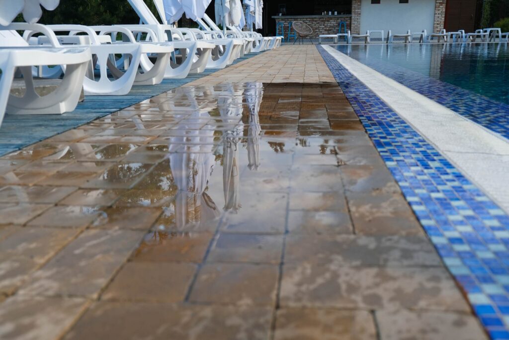 Un charco de agua cerca de una piscina ilustrando riesgos de resbalones y ca&iacute;das en Florida y la responsabilidad del propietario.